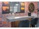 Bar area featuring a sleek countertop, comfortable seating, exposed brick, and art creating a modern, inviting space at 10251 Ebb Tide Ln, Orlando, FL 32821
