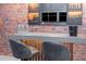 A stylish bar area with a sleek countertop, comfortable seating, and exposed brick for a modern, inviting space at 10251 Ebb Tide Ln, Orlando, FL 32821