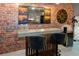 Recreational room wet bar featuring brick accent wall, mounted liquor art, and bar seating at 10251 Ebb Tide Ln, Orlando, FL 32821