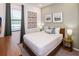 Charming bedroom featuring a window, neutral colored walls, a bed, and a side table with a lamp at 10251 Ebb Tide Ln, Orlando, FL 32821