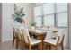 Bright dining room with a wooden table, white chairs, and natural light from large windows at 10251 Ebb Tide Ln, Orlando, FL 32821