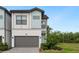 Modern two-story home with a grey garage door, light blue siding, and a well-manicured lawn at 10251 Ebb Tide Ln, Orlando, FL 32821
