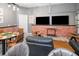Expansive game room with exposed brick, leather furniture, dual TV setup, poker table and access to the garage at 10251 Ebb Tide Ln, Orlando, FL 32821