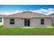 Home backyard with a well-maintained lawn and sliding glass doors, perfect for outdoor enjoyment at 1120 Saguaro St, Haines City, FL 33844