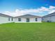 A home with a large green backyard and sliding glass doors leading to the house at 1120 Saguaro St, Haines City, FL 33844