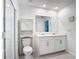 Bright bathroom with double vanity, white cabinets, and walk-in shower with glass doors at 1120 Saguaro St, Haines City, FL 33844