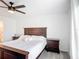 Bright bedroom with a ceiling fan, plush carpet, and a wooden bed frame and side tables at 1120 Saguaro St, Haines City, FL 33844