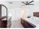 Spacious bedroom features a dark wood dresser and furnishings with neutral carpeting and ceiling fan at 1120 Saguaro St, Haines City, FL 33844