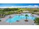 Aerial view showcases a stunning community pool with lush landscaping and plenty of seating at 1120 Saguaro St, Haines City, FL 33844