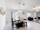 Open-concept dining room with a modern chandelier and large windows allowing natural light at 1120 Saguaro St, Haines City, FL 33844