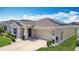 Lovely one-story home featuring a two-car garage, manicured lawn, and a solar panel system on the roof at 1120 Saguaro St, Haines City, FL 33844