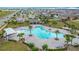 Aerial view of community pool and amenities featuring chairs, umbrellas and ample greenery around pool at 1120 Saguaro St, Haines City, FL 33844