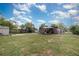A large backyard with a storage shed and patio with furniture, all enclosed by a chain link fence at 11509 Cameron St, Orlando, FL 32817