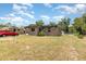 A house with a tan exterior, a chain link fence, and a large, grassy yard at 11509 Cameron St, Orlando, FL 32817