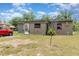 Single story home with a tan exterior and a red car parked in the front yard at 11509 Cameron St, Orlando, FL 32817