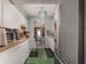 A kitchen with white cabinetry, green floors, and stainless steel appliances at 11509 Cameron St, Orlando, FL 32817