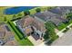 Aerial view of a well-maintained home with a private pool, lush landscaping, and a serene lake backdrop at 11707 Hampstead St, Windermere, FL 34786