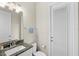 A well-lit bathroom featuring a granite countertop sink and a door with a built-in window for natural light at 11707 Hampstead St, Windermere, FL 34786