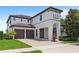 Two-story home with a two-car garage, white exterior, brown tile roof and a brick driveway, complemented by lush landscaping at 11707 Hampstead St, Windermere, FL 34786