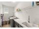 Clean laundry room equipped with modern washer/dryer, ample counter space, and shelving for organized storage at 11707 Hampstead St, Windermere, FL 34786