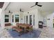 Outdoor patio with a dining table, grill, and ceiling fans for comfortable entertaining at 11707 Hampstead St, Windermere, FL 34786