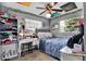 Bright bedroom with a bed, desk, shelves, and multiple windows at 1216 Floral Way, Apopka, FL 32703