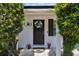 Inviting front door adorned with a wreath, flanked by manicured shrubs and vibrant potted plants at 1216 Floral Way, Apopka, FL 32703