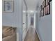 Inviting hallway with blue walls, wood floors, and decorative wall art at 1216 Floral Way, Apopka, FL 32703