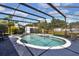 Sparkling pool inside a screened enclosure, set against a backdrop of lush greenery at 1216 Floral Way, Apopka, FL 32703