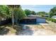 Low angle view of a charming single-story home with a porch, complemented by mature trees at 1229 Deneece Ter, Daytona Beach, FL 32117