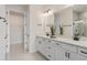 Modern bathroom with double sinks, white cabinetry, and sleek black fixtures at 13551 Pearl Beach St, Winter Garden, FL 34787
