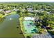 Scenic aerial shot of tennis courts and a community pool surrounded by lush greenery and a lake at 140 Deer Lake Cir, Ormond Beach, FL 32174