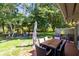 Spacious backyard with patio, dining table, umbrella and a swing set in the background at 140 Deer Lake Cir, Ormond Beach, FL 32174