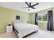 Cozy bedroom featuring a ceiling fan and a large window with tree views at 140 Deer Lake Cir, Ormond Beach, FL 32174