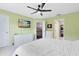 Bright bedroom with a ceiling fan, wall-mounted TV, and large dresser with drawers at 140 Deer Lake Cir, Ormond Beach, FL 32174