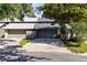 Home featuring multiple garages with stone detailing and an American flag at 140 Deer Lake Cir, Ormond Beach, FL 32174