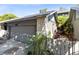 Attached garage featuring a stone accent wall and lush landscaping at 140 Deer Lake Cir, Ormond Beach, FL 32174