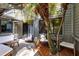Outdoor patio with cozy seating and a small deck, surrounded by lush tropical foliage at 140 Deer Lake Cir, Ormond Beach, FL 32174