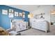 This lovely Bedroom features a soft blue accent wall, a crib, and a dresser at 1495 Fountain View St, Ormond Beach, FL 32174