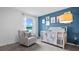 This adorable Bedroom features a soft color palette, a crib, and a comfortable glider at 1495 Fountain View St, Ormond Beach, FL 32174