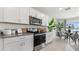 Well-lit kitchen featuring white cabinetry, granite countertops, stainless appliances, and modern decor at 1495 Fountain View St, Ormond Beach, FL 32174