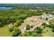 Aerial shot showcasing a large property with mature trees, a pool, and proximity to a serene lake at 1508 Lake Mills Rd, Chuluota, FL 32766