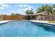 Inviting kidney-shaped pool with sun deck and fenced in yard near the house at 1508 Lake Mills Rd, Chuluota, FL 32766