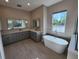 Elegant bathroom with a soaking tub, double vanity, and plenty of natural light at 160 Steeplechase Cir, Sanford, FL 32771