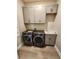Convenient laundry room with modern washer and dryer, cabinets, and utility sink at 160 Steeplechase Cir, Sanford, FL 32771