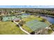 Aerial view of community athletic courts, including tennis and basketball, near a lake at 1716 Wild Indigo Ter, Oviedo, FL 32766