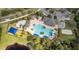 Aerial view of the community clubhouse with multiple pools, lounge areas, cabanas, and parking on a manicured property at 1716 Wild Indigo Ter, Oviedo, FL 32766