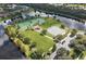Aerial view of lakeside community featuring tennis and basketball courts and recreational facilities at 1716 Wild Indigo Ter, Oviedo, FL 32766