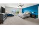 Bright bedroom featuring a king-sized bed, blue accent wall, and large window at 1716 Wild Indigo Ter, Oviedo, FL 32766