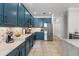 A spacious kitchen featuring marble countertops, stainless steel appliances, and modern blue cabinets at 1716 Wild Indigo Ter, Oviedo, FL 32766